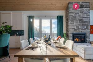 a dining room with a table and a fireplace at The Green Chill at Cité-Jardin - Private SPA, Ping pong, Fireplace & Pool in Saint-Basile