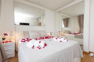 Un dormitorio con una cama blanca con flores rojas. en Bw Apartments Lux - Belgrade Waterfront, en Sajmište