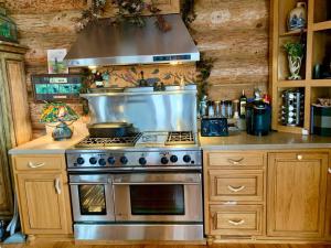 a kitchen with a stainless steel stove and wooden cabinets at LUXURIOUS TN Mtn Lodge- Sleeps 22+, Hiking & Lake in Butler +42 photos