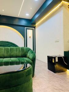 a living room with a green couch and a table at my pad stay in Lucknow