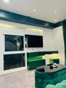 a living room with a green couch and a tv at my pad stay in Lucknow