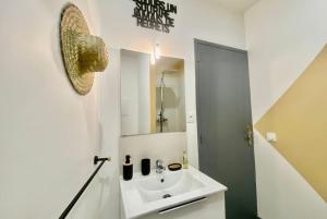a bathroom with a sink and a mirror at Le Kozy - Chambre hôtel en plein coeur de ville in Nîmes