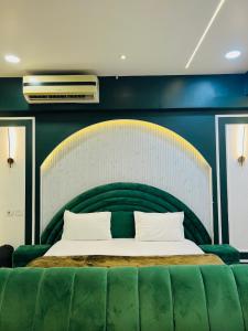 a bedroom with a large bed with a green couch at my pad stay in Lucknow