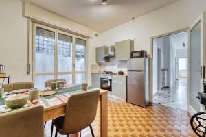 uma cozinha com uma mesa de jantar e uma cozinha com um frigorífico em CASA IDA apartment free parking em Cernobbio