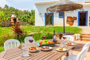 een houten tafel met een schaal fruit en wijnglazen bij Countryside Retreat House in Monchique
