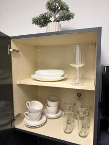a cupboard with dishes and glasses and a plate at Talblick - Bad Griesbach THERME 26qm in Oberham