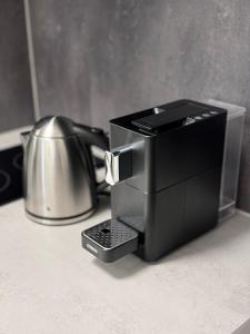 a coffee maker on a counter next to a tea kettle at Talblick - Bad Griesbach THERME 26qm in Oberham