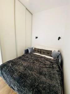 een slaapkamer met een bed met een deken erop bij Rozmarynowy in Opole