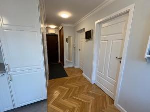 korytarz z białymi drzwiami i drewnianą podłogą w obiekcie Apartament 333 w Warszawie