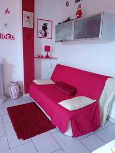 um sofá vermelho num quarto com um cobertor vermelho em Dalla Rossa em Montelupo Fiorentino