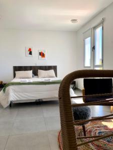 un dormitorio con una cama y una silla en Comodo Monoambiente en puerto madryn, en Puerto Madryn