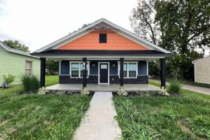 ein orangefarbenes und blaues Haus mit einem Bürgersteig davor in der Unterkunft Amazing riverside New Construction home in Middletown in Middletown