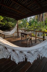 a hammock on a deck with a table at ALTO MAR by Alto Atins in Atins