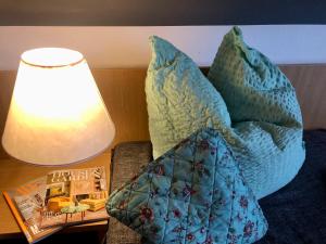 a pillow on a couch next to a table with a lamp at B&B Hotel Goldener Hahn - Guesthouse Hirsch Baiersbronn in Baiersbronn