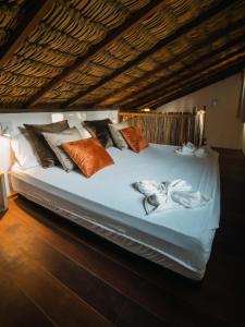 Un dormitorio con una cama blanca con muchas almohadas en ALTO MAR by Alto Atins, en Atins
