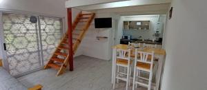 a small room with a staircase and a kitchen with a counter at Schönes Loft in Villa General Belgrano