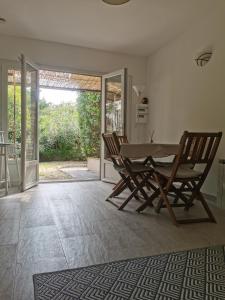 una sala da pranzo con tavolo e 2 sedie di Studio jardin privatif 300m de la plage a Sainte-Maxime