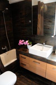 W łazience znajduje się umywalka, toaleta i lustro. w obiekcie Glyfada Luxury w Atenach