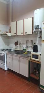 kuchnia z białymi szafkami i piekarnikiem w obiekcie Nuestro Quincho w mieście La Rioja