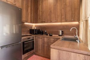 a kitchen with wooden cabinets and a stainless steel refrigerator at Samos Tropic Apartments in Ríva