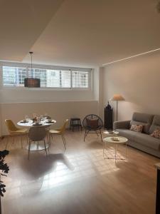 a living room with a couch and a table and chairs at Soho Moraleja I in Alcobendas