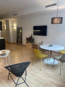 a living room with tables and chairs and a tv at Soho Moraleja I in Alcobendas