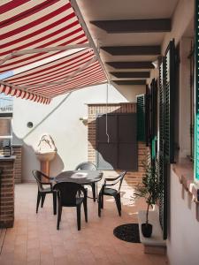 Il dispose d'une cuisine et d'une terrasse avec une table et des chaises. dans l'établissement Splendida Casa in Centro a Barbaresco, à Barbaresco
