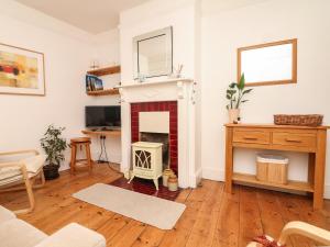 a living room with a fireplace and a desk at Shipwrights Cottage in Teignmouth