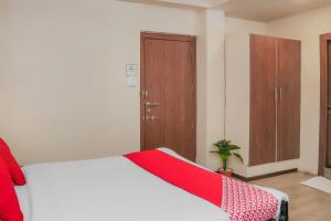 a bedroom with a bed with a red blanket on it at Super Collection O Hotel Pearl Near Shaniwar Wada in Pune