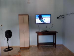 クーニャにあるchalé 8a 4の壁にテレビとテーブルが備わる客室です。