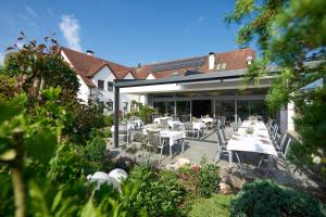 ein Restaurant mit weißen Tischen und Stühlen auf einer Terrasse in der Unterkunft Hotel Staffler in Odelzhausen
