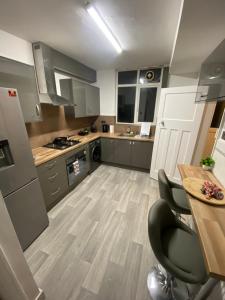 een keuken met grijze kasten en een houten vloer bij House Parking Contractors in Leicester