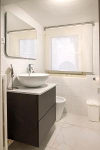 a white bathroom with a sink and a mirror at O01 - Osimo, trilocale ristrutturato in centro storico in Osimo