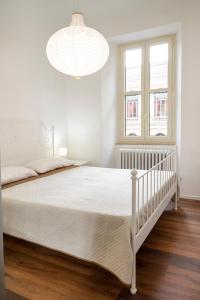 a white bedroom with a white bed and a chandelier at O01 - Osimo, trilocale ristrutturato in centro storico in Osimo