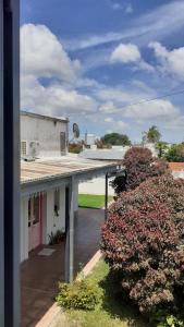 瓜萊瓜伊的住宿－Apart Bienestar，享有带门廊和灌木丛的建筑景致。