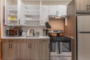 une cuisine avec des armoires blanches et une cuisinière dans l'établissement 40 OFF 3Days, 9 min to EWR, 2 Queen Beds, Sleeps 6, à Newark