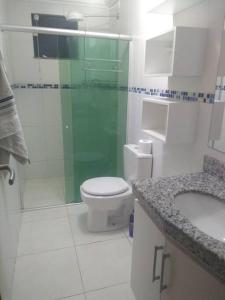 ein Bad mit einer Dusche, einem WC und einem Waschbecken in der Unterkunft #Apto a beira-mar na Praia do Sul de Ilhéus in Ilhéus
