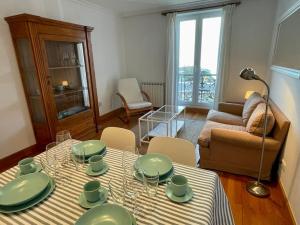 a living room with a table with green dishes on it at Apartamento frente al Kursaal y la playa in Donostia-San Sebastián +7 photos