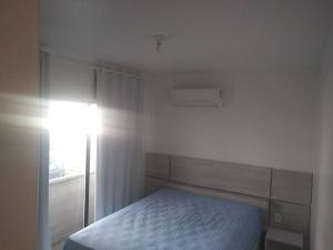 ein weißes Schlafzimmer mit einem Bett und einem Fenster in der Unterkunft #Apto a beira-mar na Praia do Sul de Ilhéus in Ilhéus