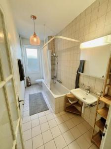 een badkamer met een bad, een wastafel en een douche bij Cozy Central 1BD Fast WiFi in Bern