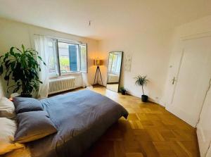 een slaapkamer met een groot bed en een groot raam bij Cozy Central 1BD Fast WiFi in Bern