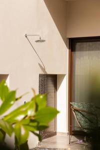 a plant in front of a building with a shower at Samos Tropic Apartments in Ríva