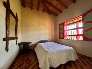 1 dormitorio con cama y ventana en RESIDENCIA ARTISTICA Y HOSTAL LOS COLORES, en Jericó