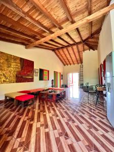 sala de estar con suelo de madera y techo de madera en RESIDENCIA ARTISTICA Y HOSTAL LOS COLORES, en Jericó