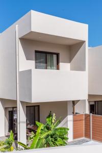 a white house with balconies and trees at Samos Tropic Apartments in Ríva