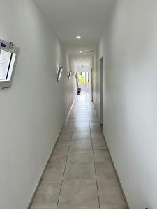 a hallway with white walls and a tile floor at Plaza Km 325 in San Lorenzo