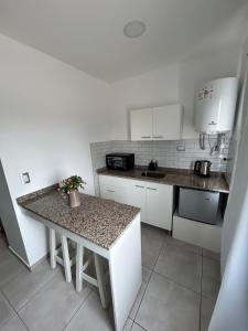 a kitchen with white cabinets and a granite counter top at Plaza Km 325 in San Lorenzo