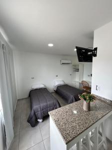 a room with two beds and a table in it at Plaza Km 325 in San Lorenzo