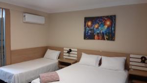 a room with two beds and a painting on the wall at Farol das Aguas in Igaratá