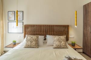 a bedroom with a large bed with two pillows at Samos Tropic Apartments in Ríva